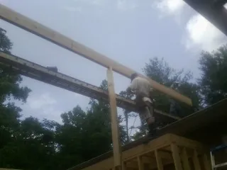 Carpenter setting a ridge beam over a new addition frame — Ice Dam Removal by Roofing Brothers in Hazleton