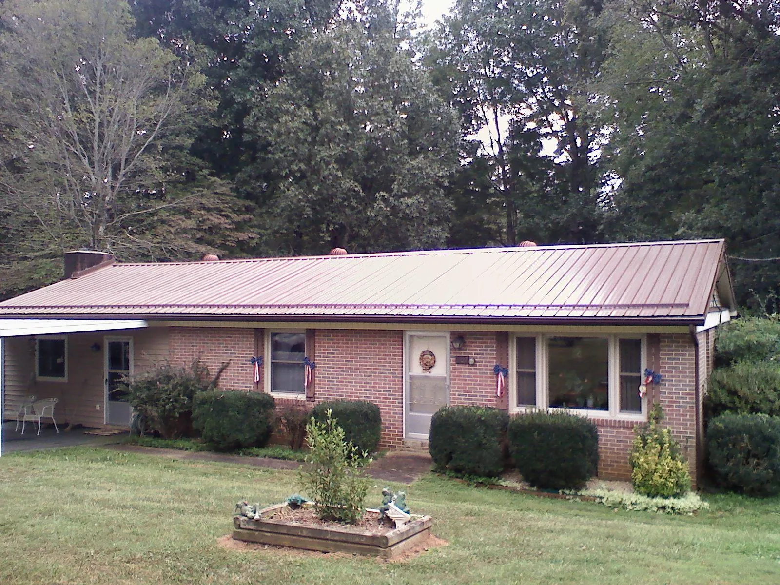 Bronze metal roof on a brick ranch home with a carport in Hazleton